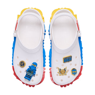 White Crocs with blue and gold Ninjago Jay Jibbitz charms on front strap