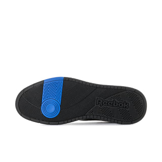 Men's Reebok sneakers outsole view with black tread and blue circular traction insert.