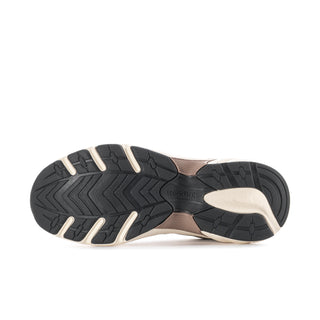 Outsole view of women’s sneakers: black tread with beige rim and patterned traction