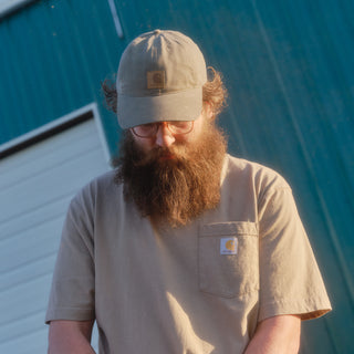 Light gray canvas dad cap with Carhartt leather patch and curved brim