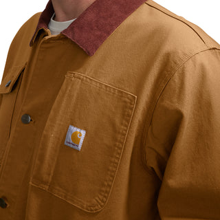Brown denim jacket close-up with sherpa-lined collar and Carhartt patch on chest