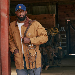 Brown denim sherpa jacket worn by man with button front and chest pocket