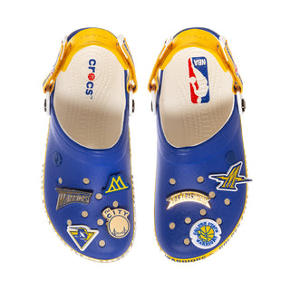 Front view of men's blue clogs with yellow insoles and decorative team patches