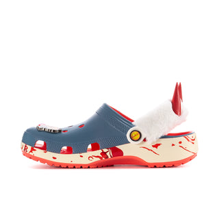 Women’s blue clog side view with white faux-fur lining, red spike detail, and graphic strap