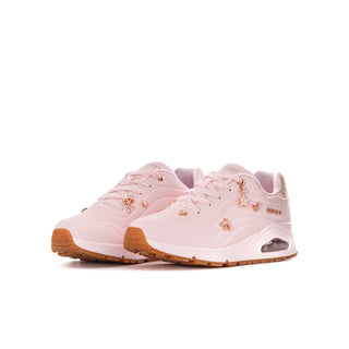 Pair of light pink youth Skechers Uno Gen1 sneakers with decorative charms and gum soles.