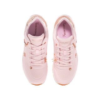 Top view of light pink youth Skechers Uno Gen1 sneakers with laces, perforations, and charms.