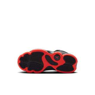 Kids sneaker outsole with red rubber pods and black tread, bottom view