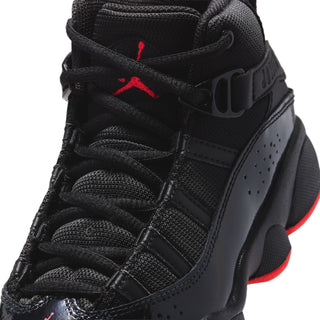 Kids black high-top sneaker with red Jumpman logo on collar, close-up