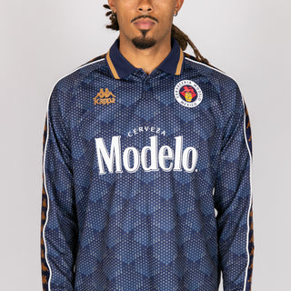 Men's navy long-sleeve jersey with 'Modelo' text and round crest patch at chest