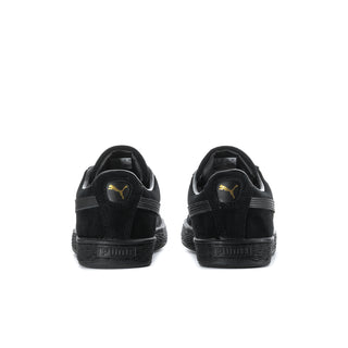 Black suede sneakers heel view with Puma logo on heel tab.