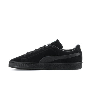Black suede low-top sneakers side view with lace-up and Puma stripe detail.