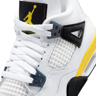 Close-up of youth white sneakers with black strap, white laces, and yellow Jumpman patch.