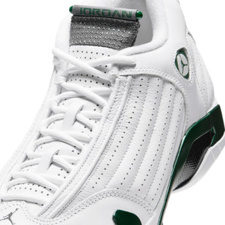Close-up of white sneaker with green heel pull tab, laces, and side stripes
