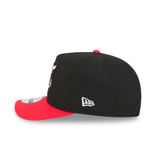 Black baseball cap with New Era logo on side and red underbrim, snapback