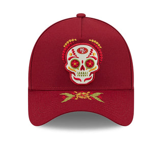 Red A-frame baseball cap with embroidered sugar skull and gold decorative accents