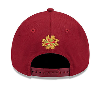 Red A-frame baseball cap with gold embroidered four-point emblem on the back