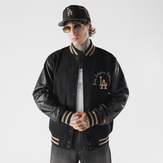 Men's black varsity jacket worn with LA logo patch, striped collar and ribbed cuffs.