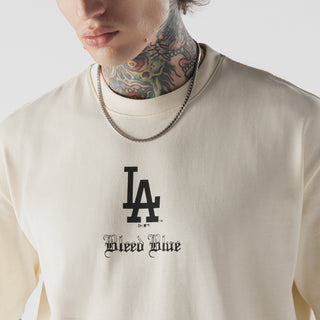 Beige T-shirt chest close-up: LA Dodgers logo and 'Bleed Blue' lettering