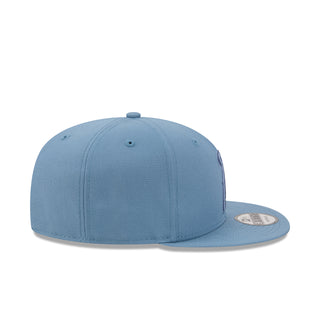 Faded blue baseball cap side profile with circular logo patch