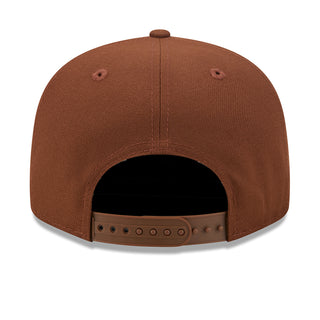 Brown baseball cap showing interior with snapback back strap and grommet holes