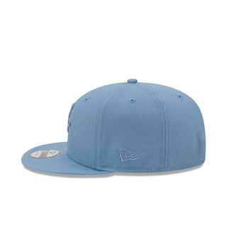 Faded blue baseball cap with small New Era side logo patch
