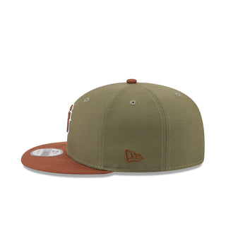Two-tone baseball cap with olive crown, auburn brim, and small embroidered side icon