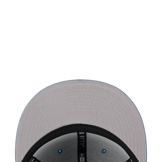 Baseball cap crown close-up with light blue fabric panels and black underbrim edge