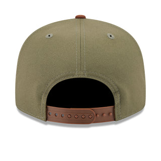 Two-tone baseball cap with olive crown, brown adjustable strap, and vent eyelets