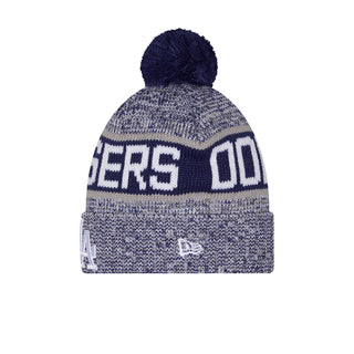 Blue knit beanie with navy pom, ribbed cuff, large back lettering.