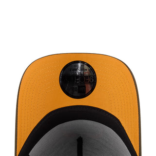 Orange baseball cap with black circular top patch