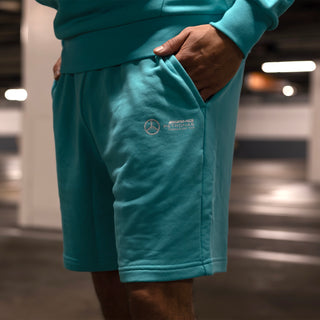 Men's teal shorts with embroidered Mercedes-AMG logo at thigh