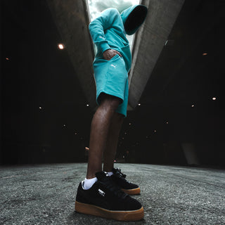Men's teal shorts with side PUMA logo and knee-length hem