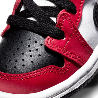 Close-up toddler mid-top sneakers: red quarter panel, black laces, perforated toe, stitched details