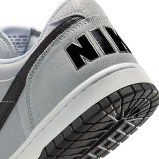 Close-up of light grey Nike panel with black stripe and “NIKE” lettering on side