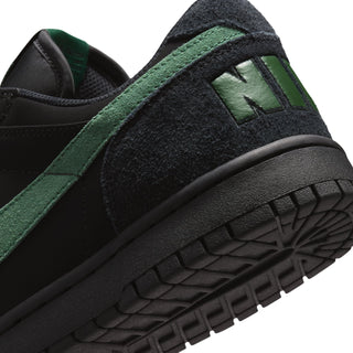 Black Nike sneaker with green trim and textured side panel detail.