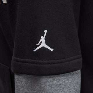 Close-up: black hoodie hem with small Jumpman logo and ribbed trim