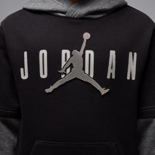 Chest close-up: Jumpman logo centered on black fleece hoodie with front pocket