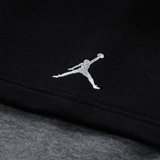 Close-up: small Jumpman logo on black hoodie sleeve cuff seam