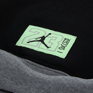 Close-up: neon green brand label with Jumpman logo on black hoodie pocket lining