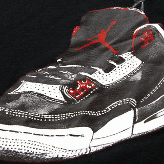 Black T-shirt close-up of sneaker graphic with red Jordan logo and white laces