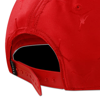 Red snapback cap close-up showing adjustable strap and stitched jacquard texture