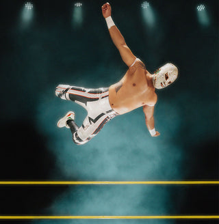 wrestler with male lucha libre mask jumping off wrestling ring
