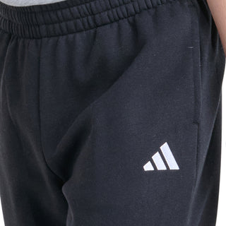 Close-up of youth black fleece jogger waistband and small adidas-style side logo