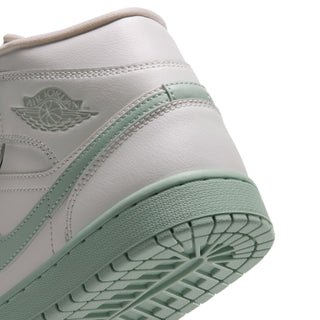 Close-up of women's mid-top sneaker quarter and outsole, mint trim on white leather