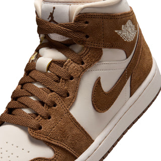 Close-up of women's mid-top sneakers with brown laces, white overlays, Air Jordan wings