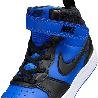 Kids mid-top sneaker close-up with blue heel tab, black laces, and white sidewall