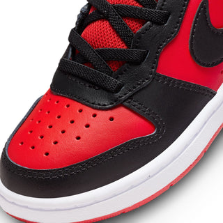 Kids' mid-top sneaker close-up, red toe with black straps, perforations, white sole