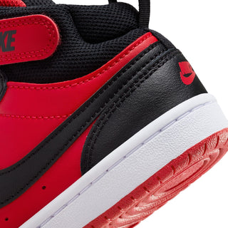 Kids' mid-top sneaker close-up, black and red side panel with white sole edge