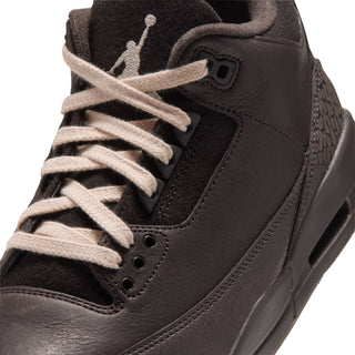 Close-up of women's retro sneaker lace area with AIR logo patch and suede collar
