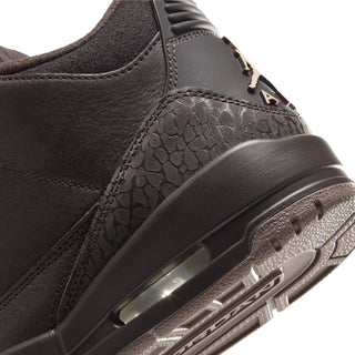 Close-up of dark brown sneaker side with textured panel, eyelets, and air window